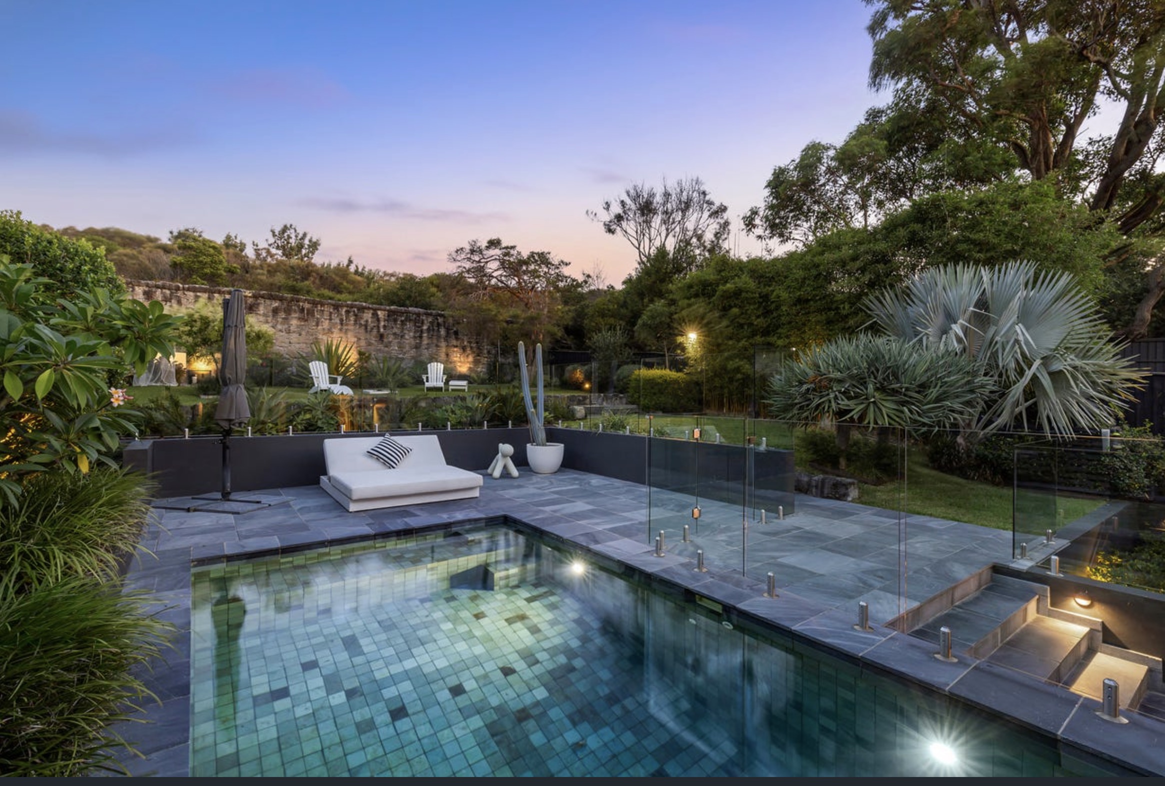 Modern backyard with tiled pool, glass fence, patio seating, and lush landscape—contact Buyers Agent seaforth today.