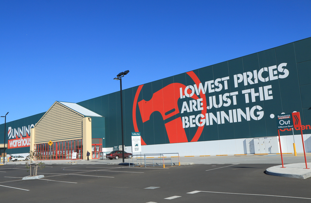 Large Bunnings Warehouse Australia building with “Lowest prices are just the beginning” and empty parking lot.