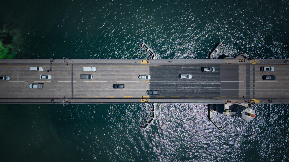 Aerial view of vehicles on Spit Bridge, a multi-lane structure over water near Seaforth with sunlight reflecting.
